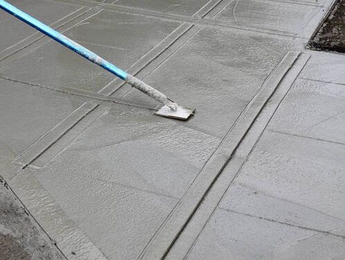 Concrete that is using a tool to create controlled cuts in the foundation