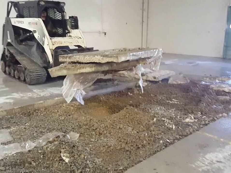 A skid steer holding concrete slabs in its bucket
