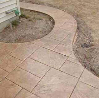 A brown stamped concrete driveway and a sidewalk